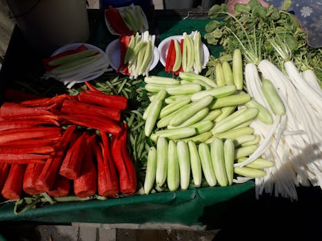 Colorful display of fresh vegetables including cucumbers, radishes, and carrots at an outdoor market.