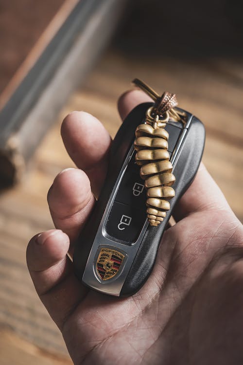 Man Hand Holding Car Key with Dragon Tail