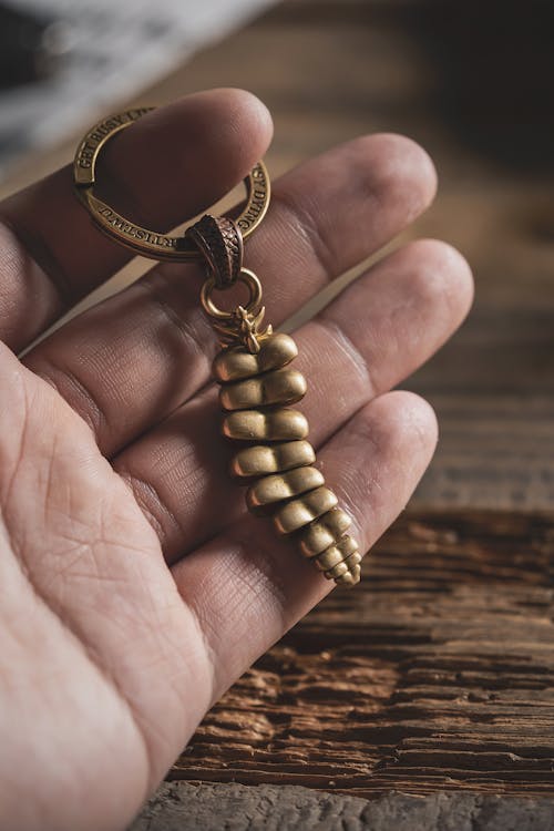 Man Hand Holding Keychain with Golden Dragon Tail