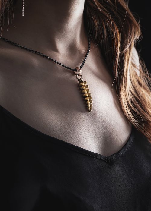 Free Close-up of a stylish woman wearing a golden pendant necklace, showcasing fashion elegance. Stock Photo