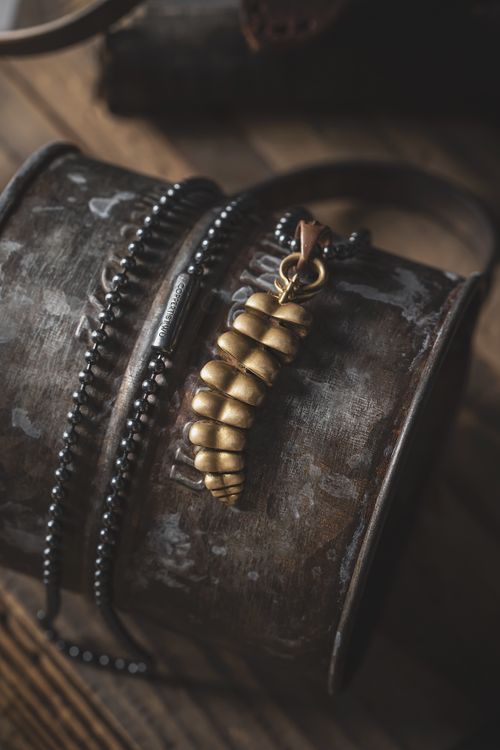 Free Vintage-style necklace with golden pendant on rustic wooden barrel. Stock Photo