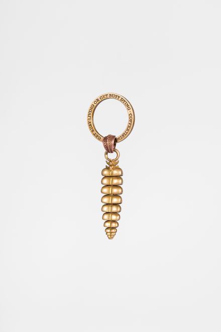 Brass spiral bag charm on a plain backdrop, photo by COPPERTIST WU on Pexels