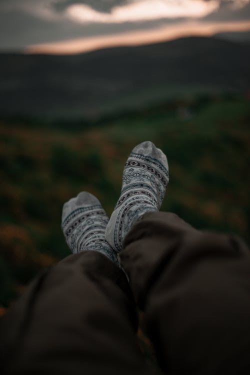 Free Feet in Nordic Pattern Socks Against Sunset Sky Stock Photo