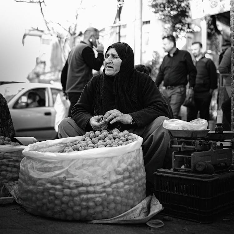 Woman Selling Walnuts On City Street