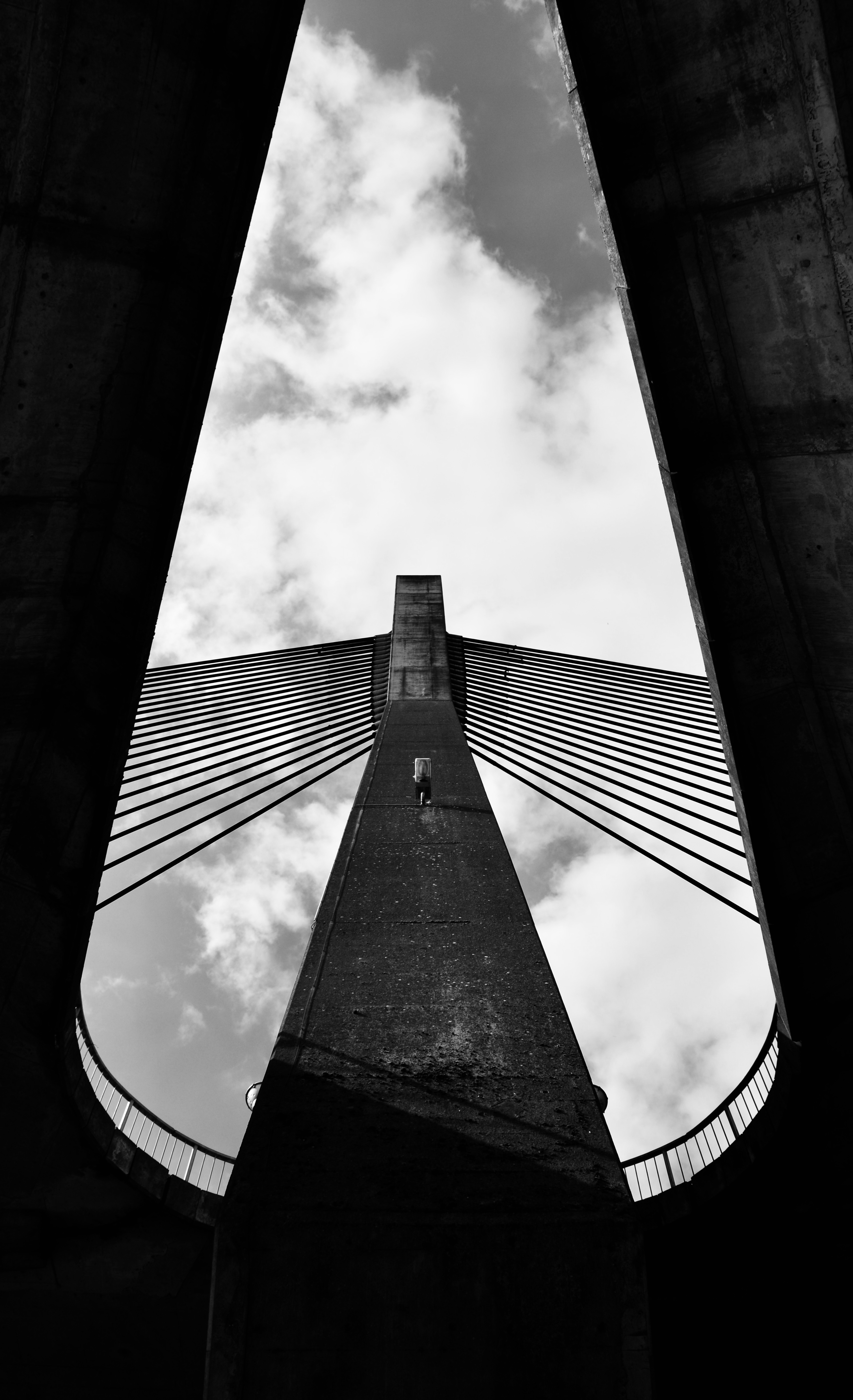 A stunning black and white view of a suspension bridge in Huy, Belgium, showcasing its architectural beauty and height.