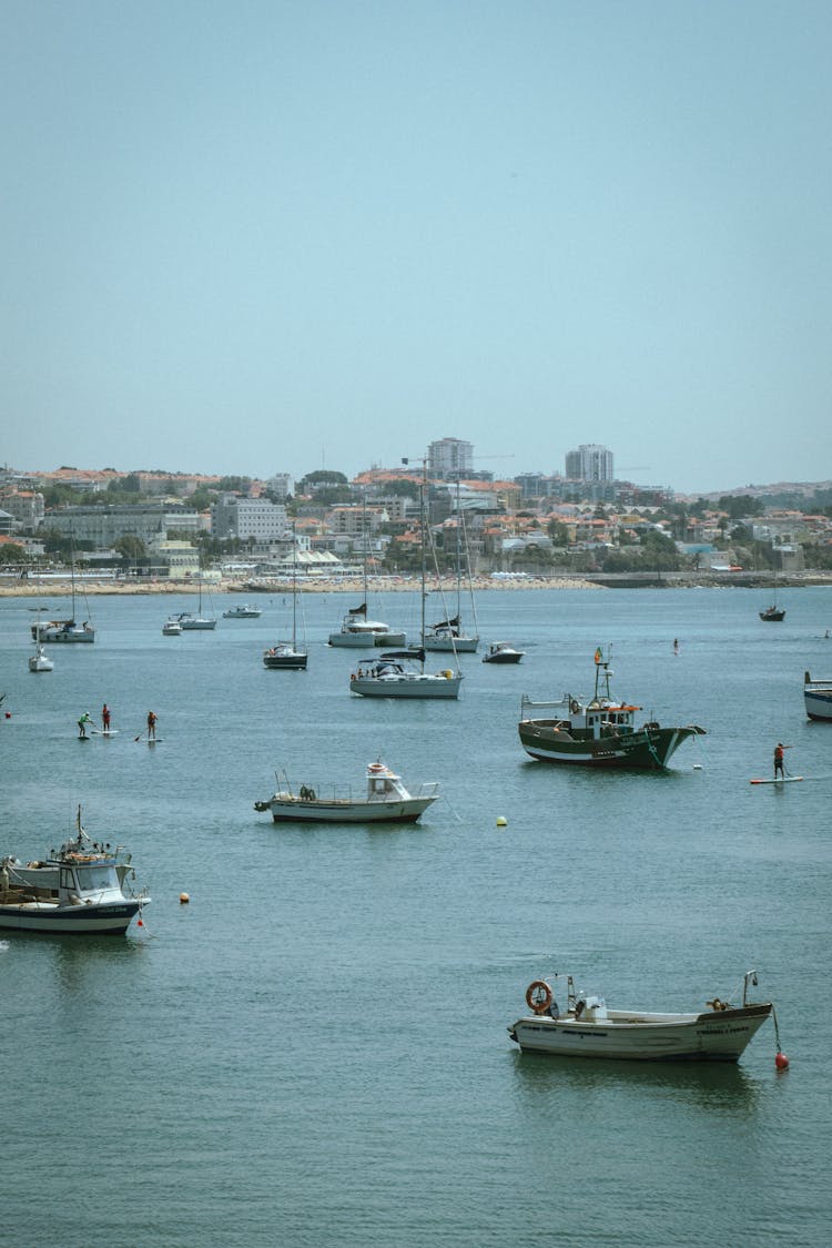 Sailboats On Sea With City In Background