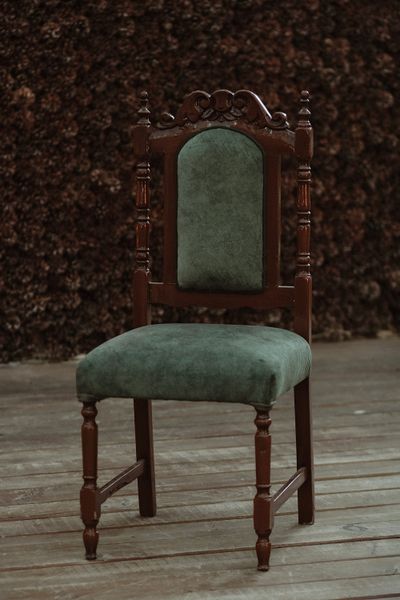Green upholstered wooden chair with carved detail — photo by Yusra Mizgin Günay on Pexels