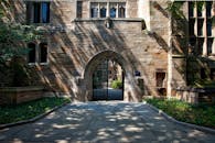 耶鲁大学校园的入口处，哥特式石制拱门被绿色植物环绕