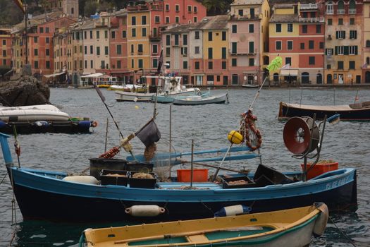 Boats anchored in a vibrant harbor with colorful buildings lining the waterfront.
