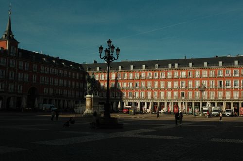 Free Sunlit view of historic Plaza Mayor in Madrid, showcasing architecture and daily life. Stock Photo