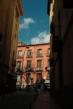 Urban scene with colorful buildings and blue sky in a historic city alleyway.