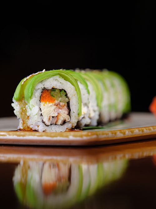 Free Tantalizing close-up of a fresh avocado sushi roll, artfully displayed. Stock Photo