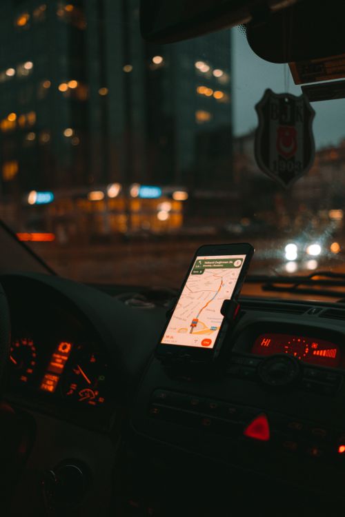 Free Car dashboard with GPS showing map on a digital screen during city driving at dusk. Stock Photo