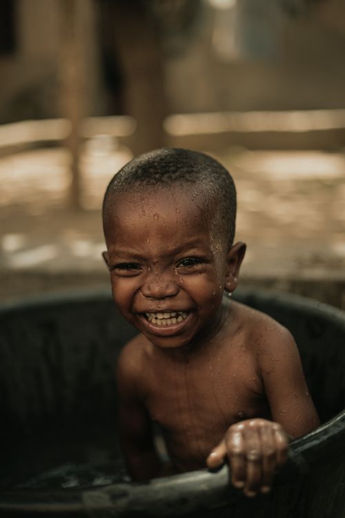 Free A happy child enjoying a playful bath outdoors, radiating joy and laughter. Stock Photo