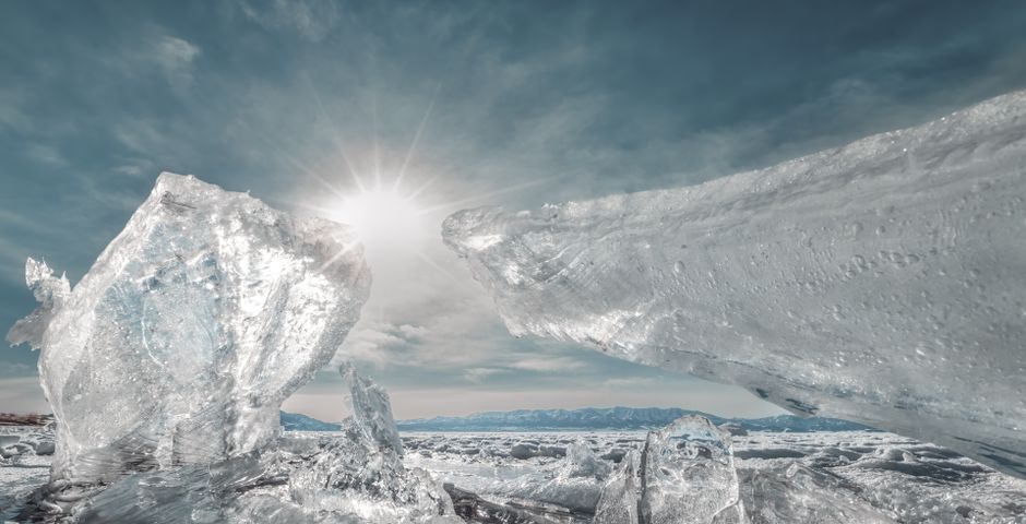 Majestic icebergs glisten under the bright sun, showcasing a serene polar landscape.