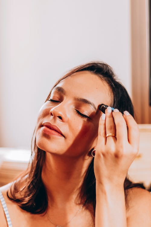 Woman Applying Beauty Product to her Face 