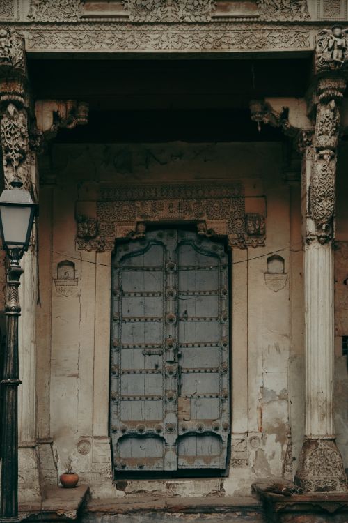 Free A beautifully carved wooden door on a historic building, showcasing traditional architecture in India. Stock Photo
