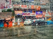 雨水覆盖的玻璃捕捉到充满活力的城市街景，展现出建筑物和车辆