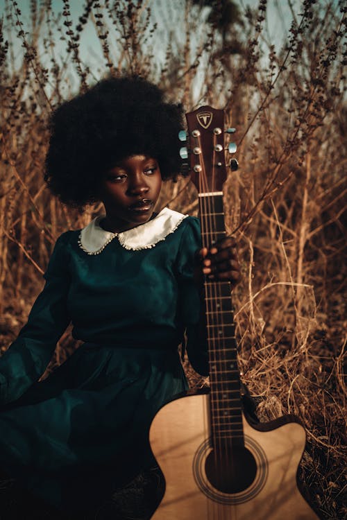 Free Teenage Girl with Guitar on Meadow Stock Photo