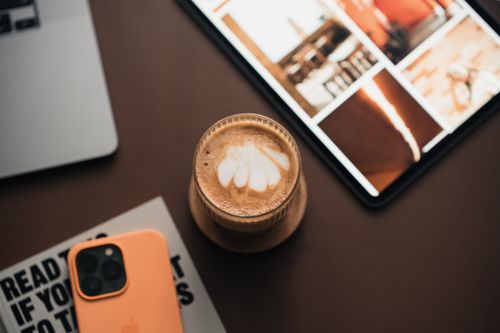 Free Warm coffee with a tablet and smartphone on a desk, ideal for productivity and relaxation. Stock Photo