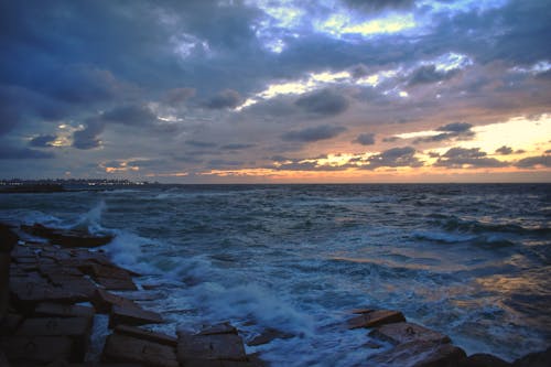 Clouds and Waves on Sea Shore at Sunset