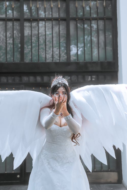 Model in Wedding Dress Wearing Angel Wings