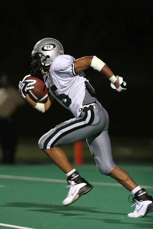 Free Football Player Holding Football Stock Photo