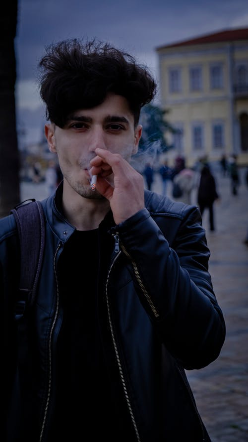 Young Man in a Leather Jacket Smoking a Cigarette