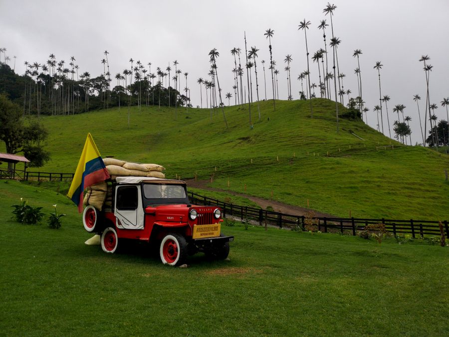 Historický jeep Willys s kolumbijskou vlajkou v zelených kopcích u Salenta