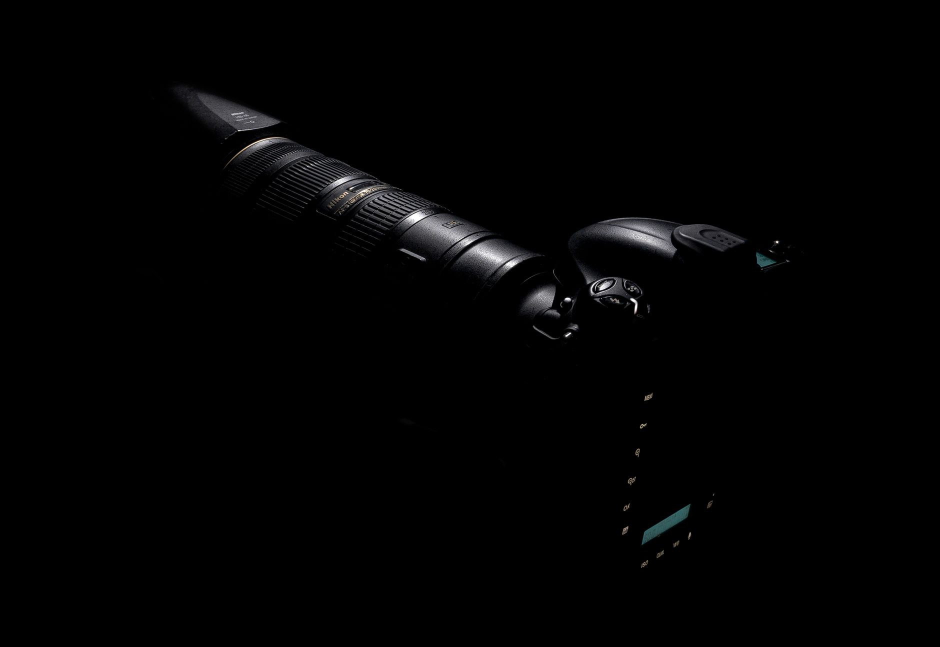 A sleek DSLR camera and lens highlighted against a dark background.