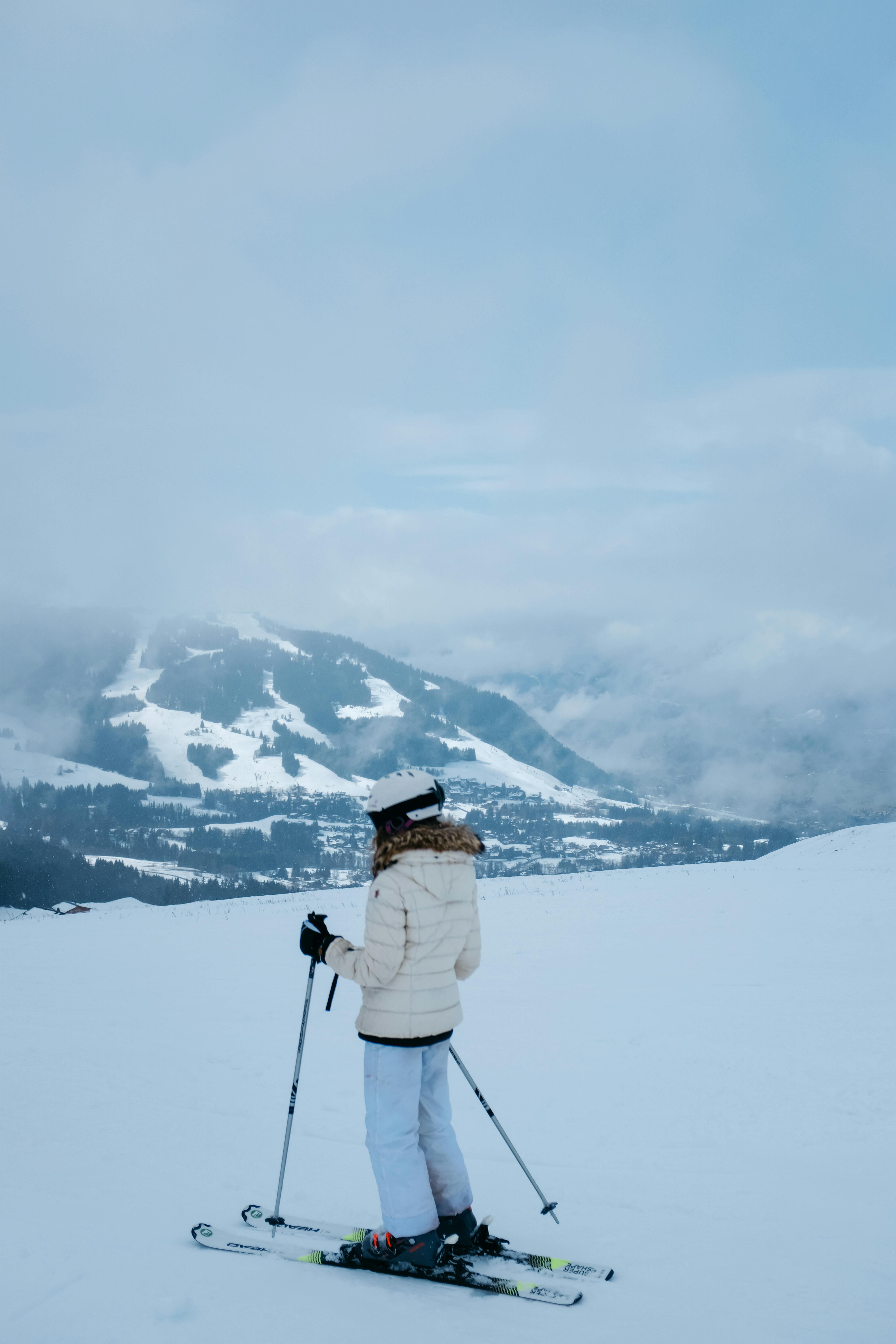 Prescription Goggle Inserts - Woman in winter attire skiing in snowy mountains, enjoying leisure time.