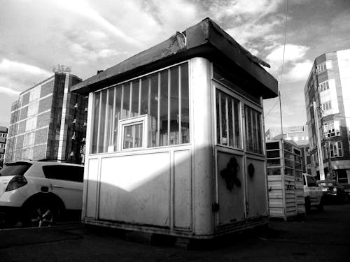Black and White Photo of an Abandoned Parking Booth at a Parking Lot in City 