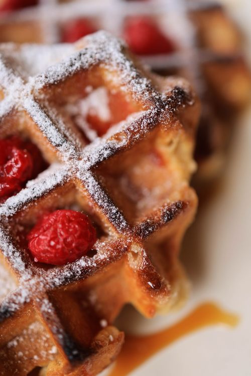 Free Close-up of freshly made waffles topped with strawberries and powdered sugar, perfect for indulgent treats. Stock Photo