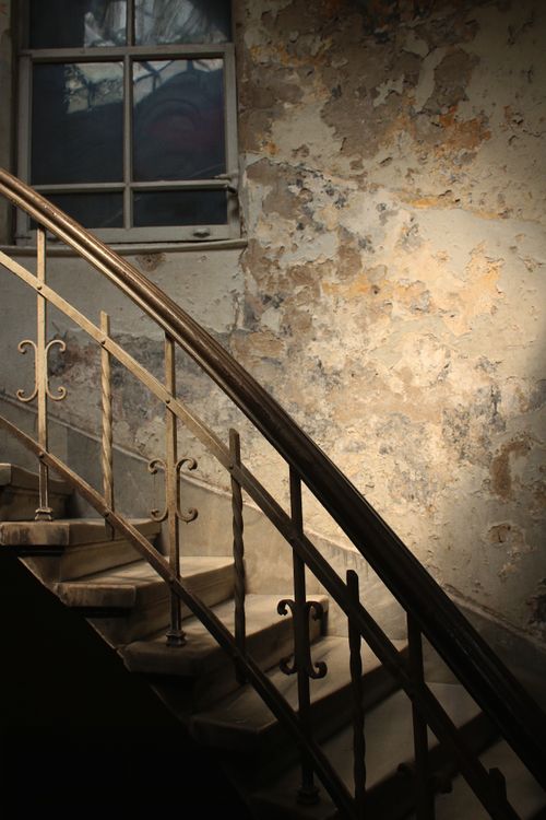 Free A vintage staircase against a decaying wall, capturing an aged interior space. Stock Photo