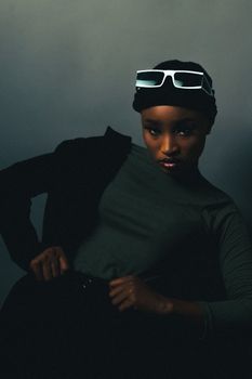 A fashionable studio portrait of a woman in sunglasses with a modern chic look.