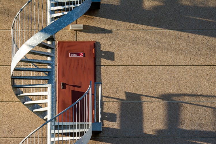 Door And Circular Stairs On Building Wall