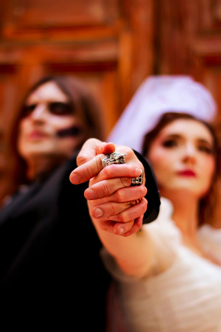 Man And Woman In Bride And Groom Halloween Costumes Holding Hands