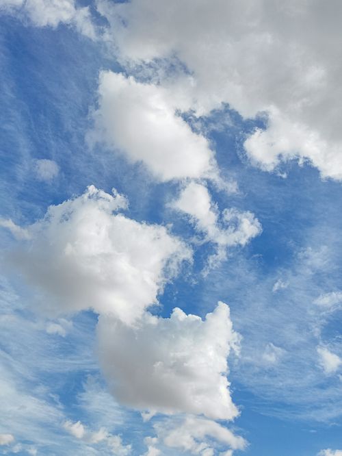 Free Vivid white clouds against a clear blue sky, perfect for nature-themed backgrounds. Stock Photo