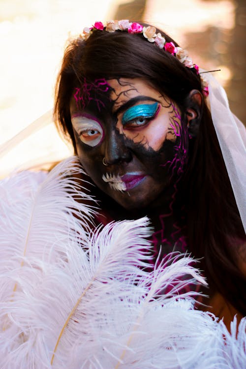 Woman in a Halloween Costume and Makeup with Half of Her Face Painted Black 