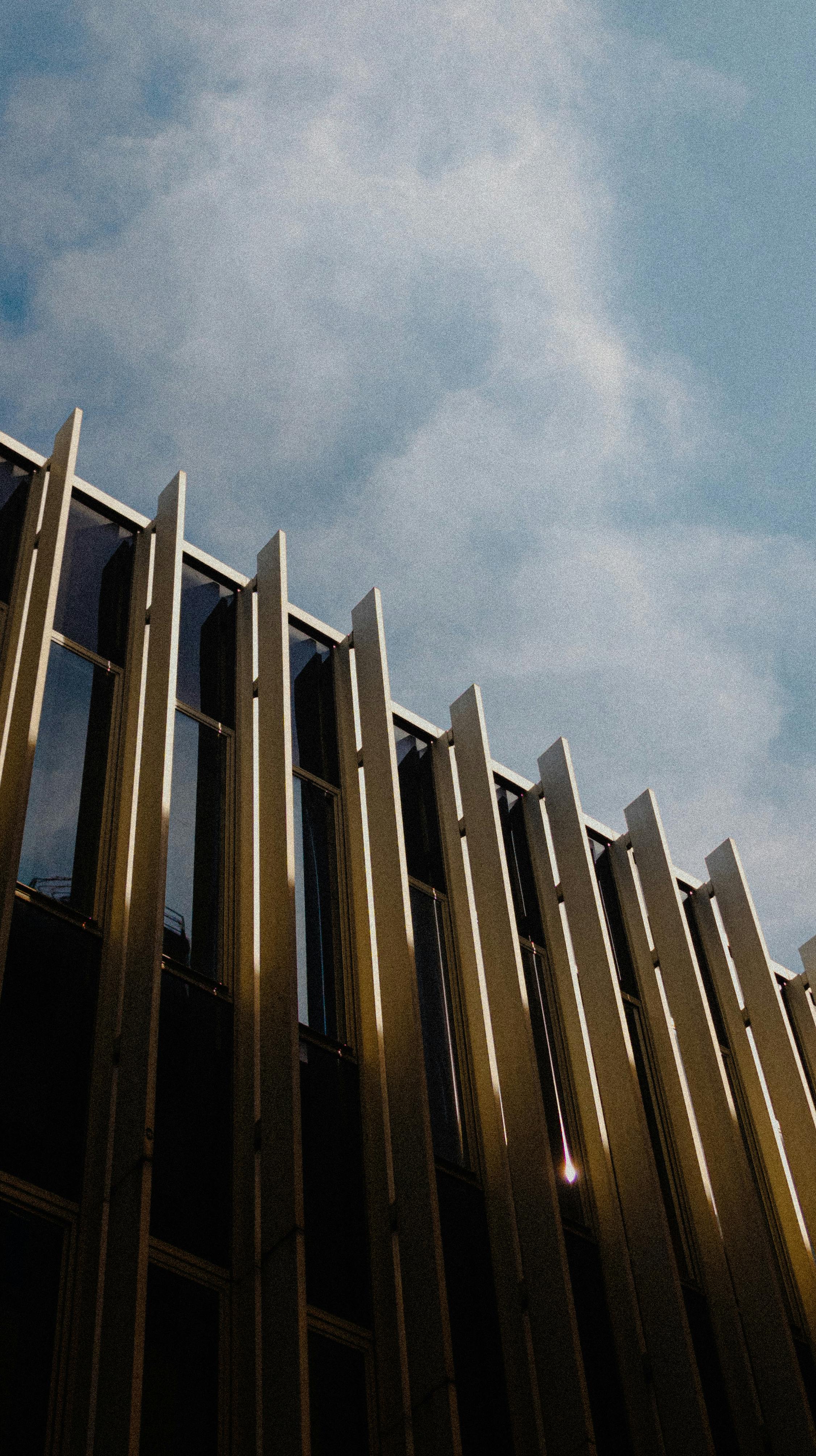 A contemporary building facade in Bologna with striking architectural elements against a clear sky.