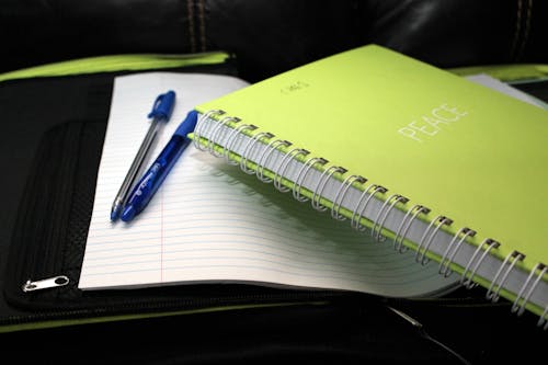 Free Green Spring Bind Book Beside 2 Blue Pens Stock Photo