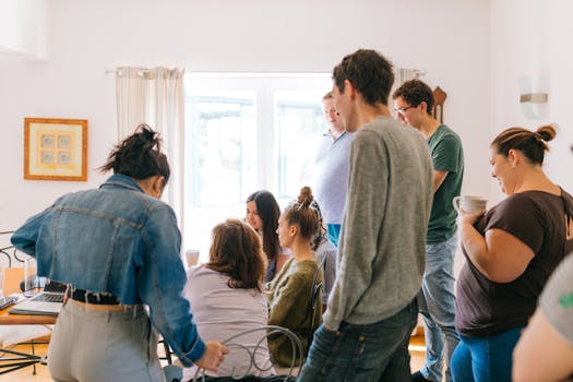 A group of adults collaborating around a table in a bright room, promoting teamwork and creativity.