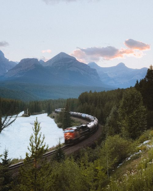 Free A train journey through a picturesque mountainous forest with a river view. Stock Photo