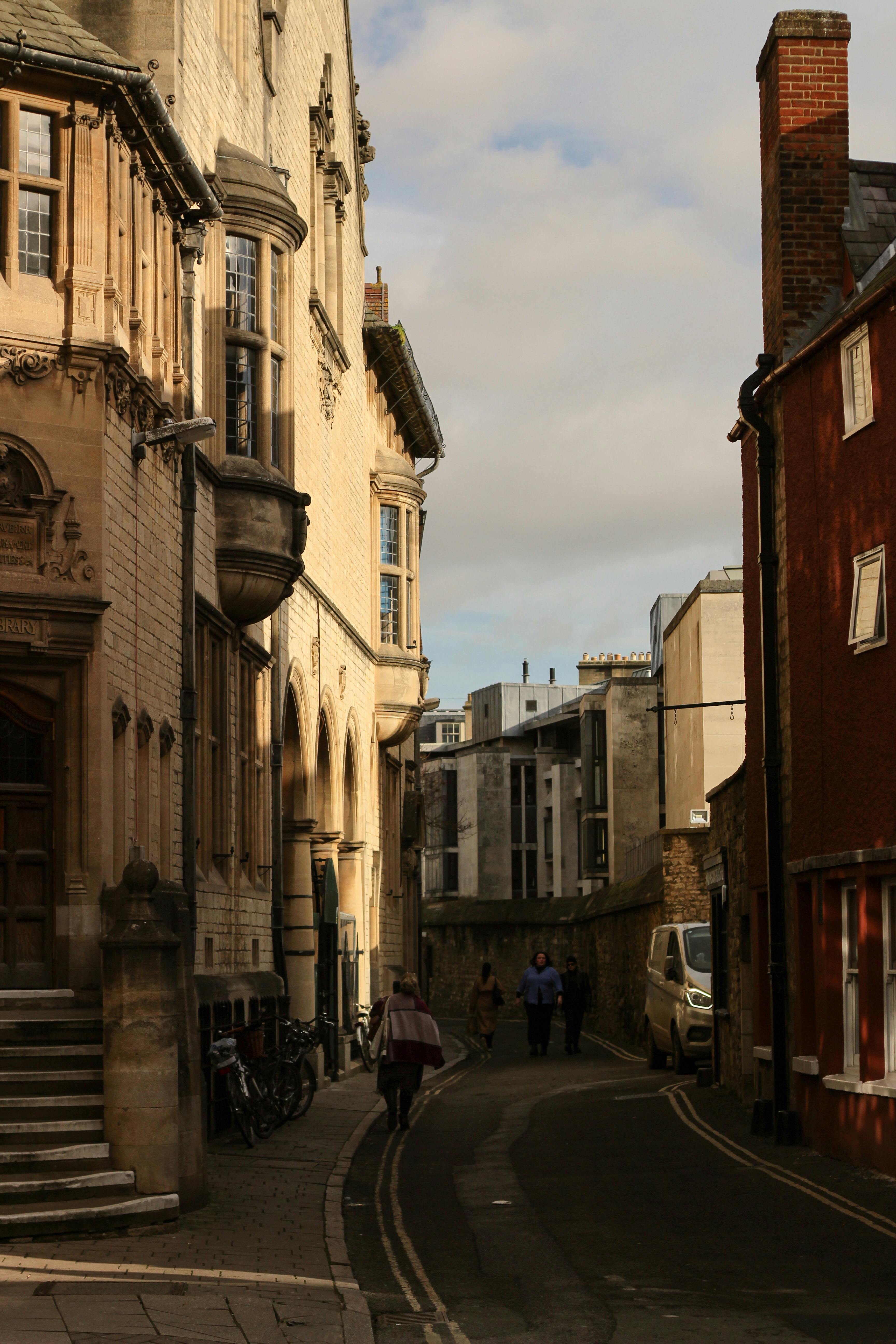 Quaint London street showcasing historic architecture with pedestrians on a sunny day.