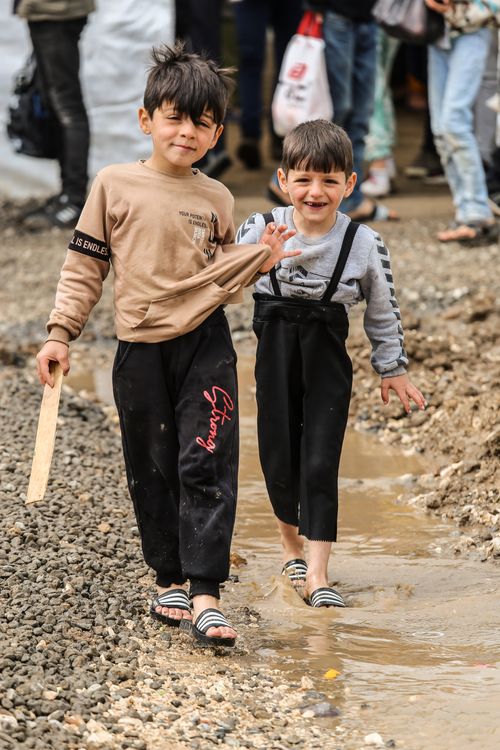 Free Two smiling boys enjoy a carefree day playing in the muddy outdoors, showcasing childhood joy and friendship. Stock Photo