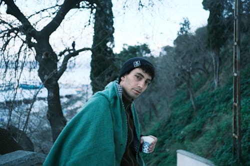 Man in Coat and Beanie in Park