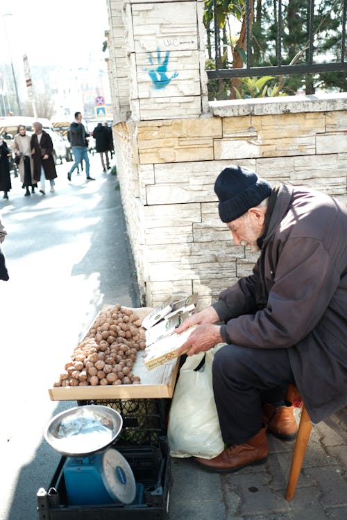 Elderly Man Selling Potatoes on the Street in City 