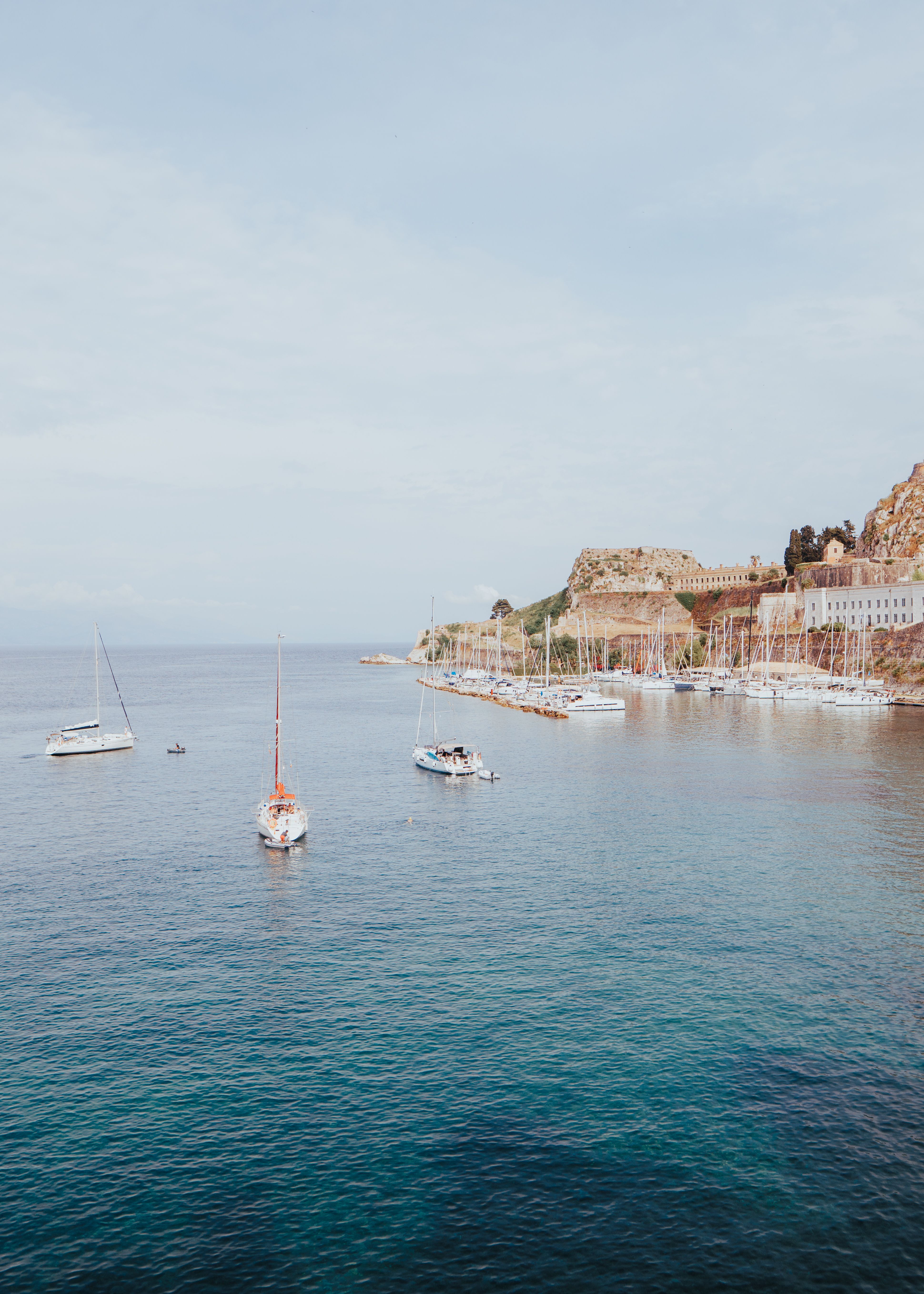 Yachts cruising near a mountainous coastline
