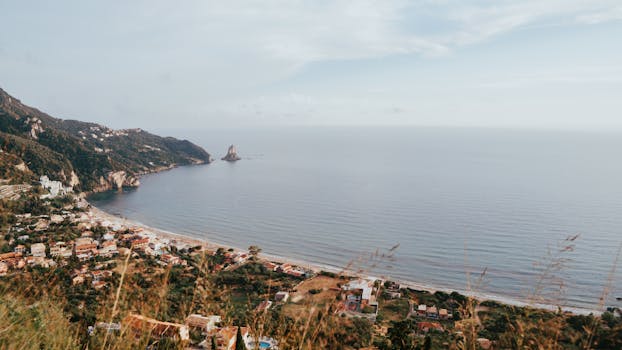 Tranquil coastal landscape of Kerkyra, Greece, featuring a serene seaside village and expansive sea view.