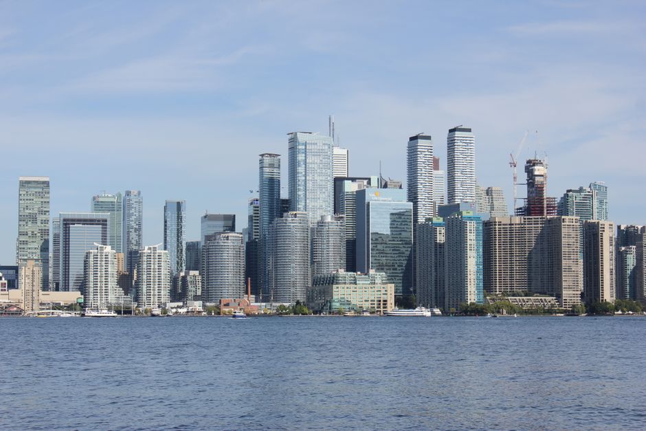 Modern Toronto skyline with skyscrapers reflected in Lake Ontario.